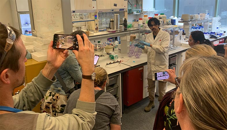 PhD student Shae Patel speaking with the ChemEd teachers during the lab tour